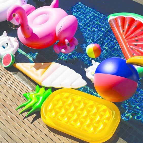 Colourful pool floaties and a beach ball in a private villa pool